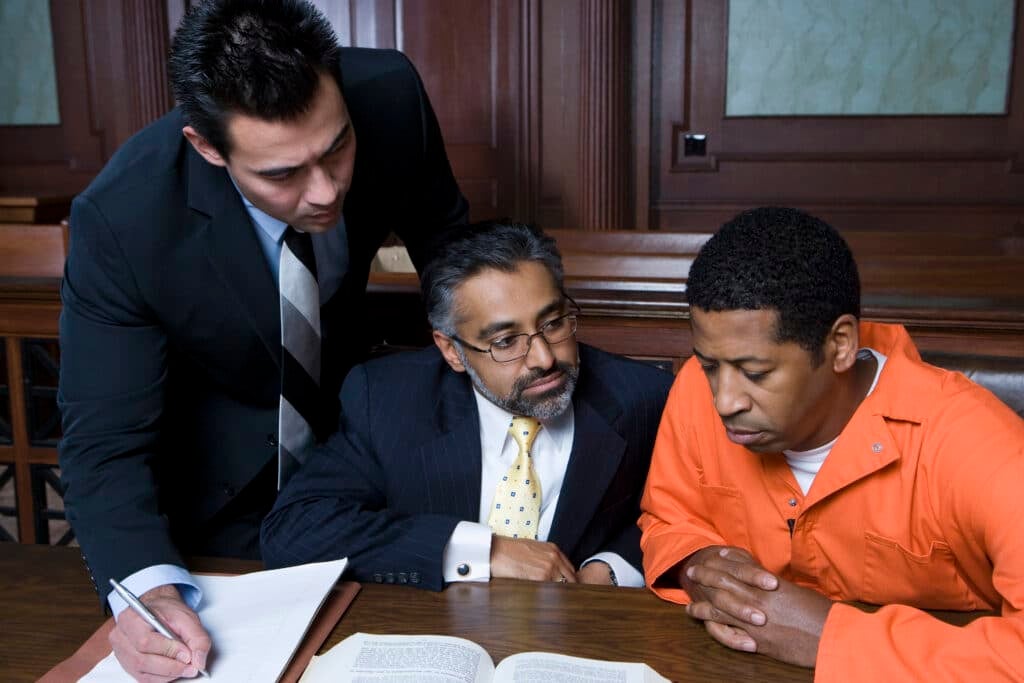Legal professionals reviewing documents related to criminal proceedings.