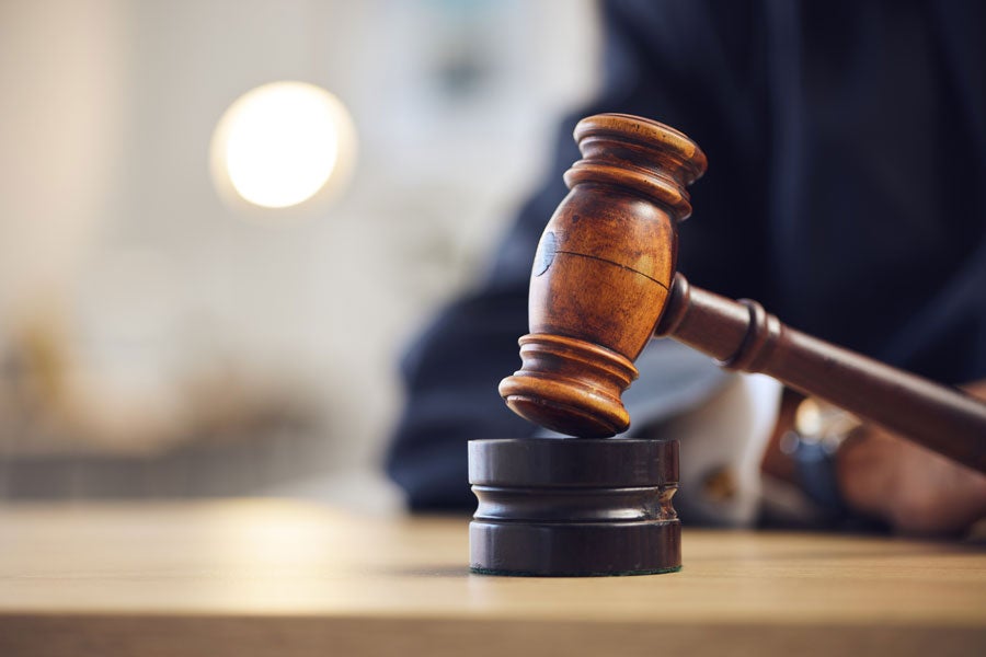 A wooden gavel rests on a round