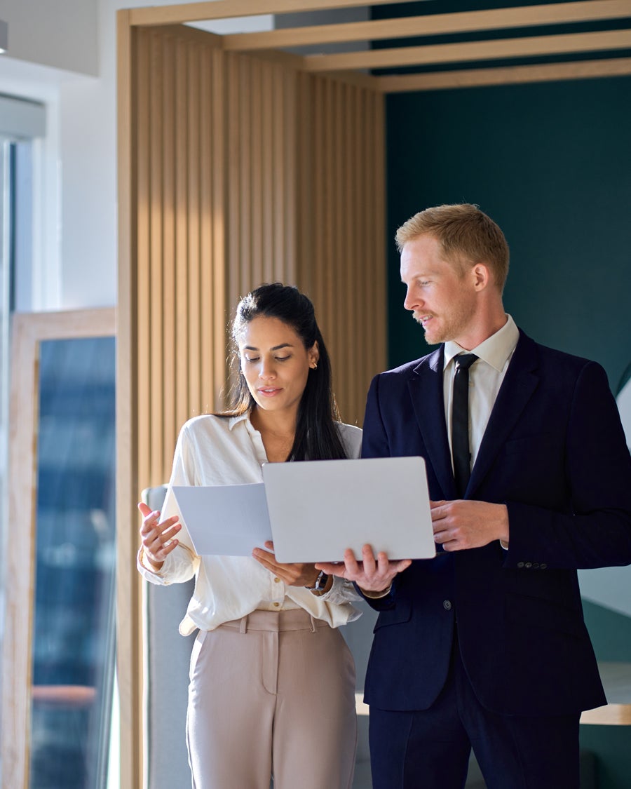 Two business professionals,reviewing documents together in a modern office.